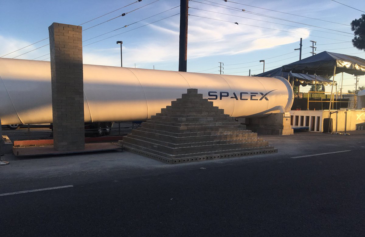 一堆无聊的公司制造的砖在一个hyperloop管前面。