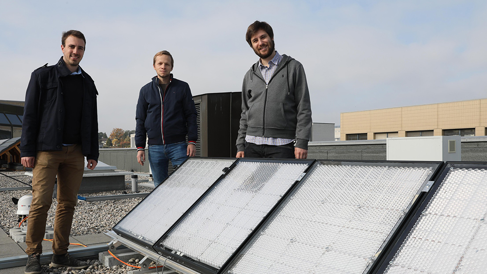 站立在一个屋顶的三个人照片由太阳电池板