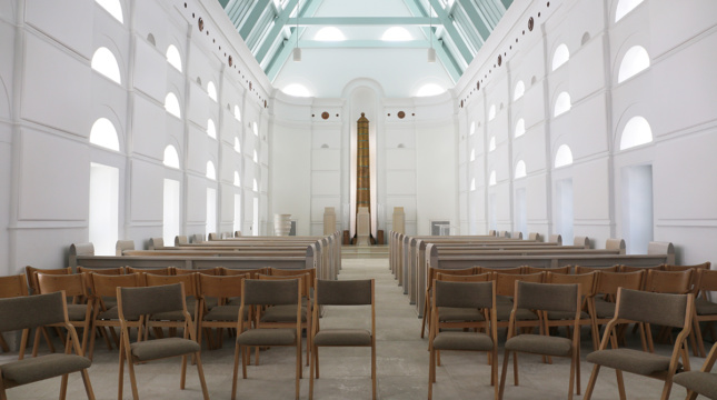 一张折叠椅摆放在充满白光的教堂内部的照片