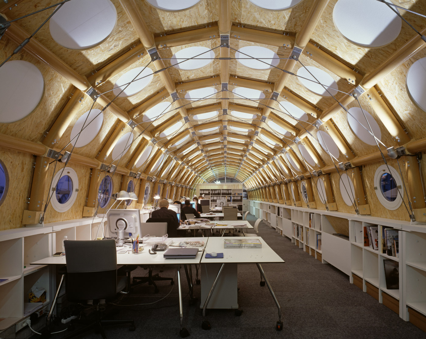 这是一张用纸筒做成的半圆形空间内的移动办公室的照片