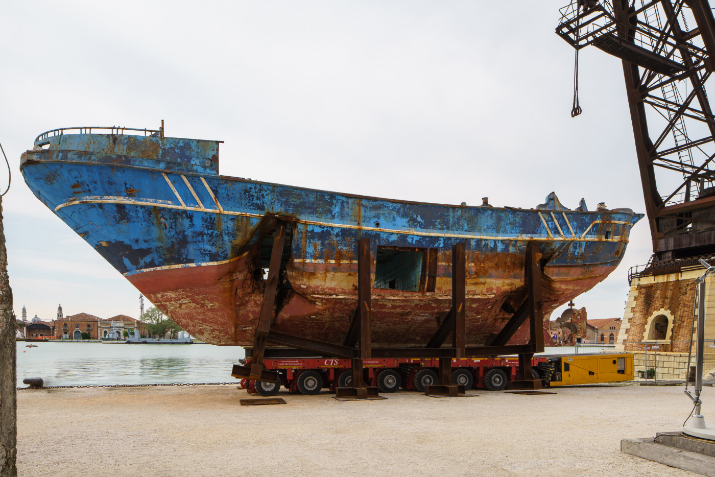 一艘生锈的船在它的一侧有一个大的凹痕，安装在混凝土上;Barca Nostra也是每日消化的一部分