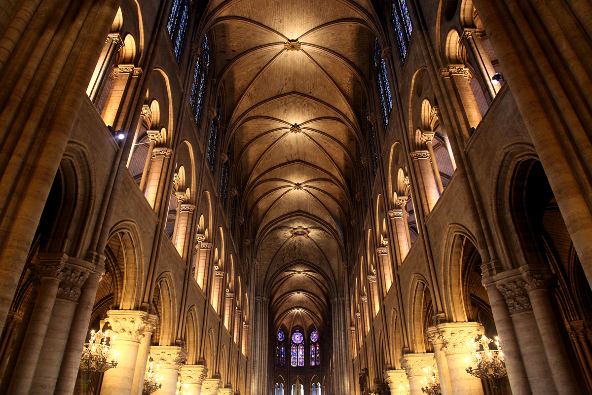 在与蜡烛点燃的保险库和专栏的Notre Dame大教堂里面的图象
