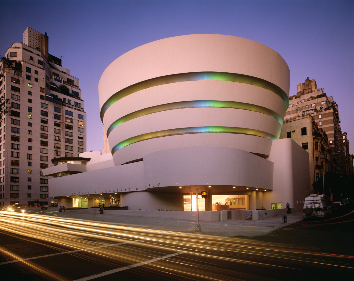 由弗兰克·劳埃德·赖特(Frank Lloyd Wright)设计的一座大型白色圆形建筑，位于一个繁忙的街角