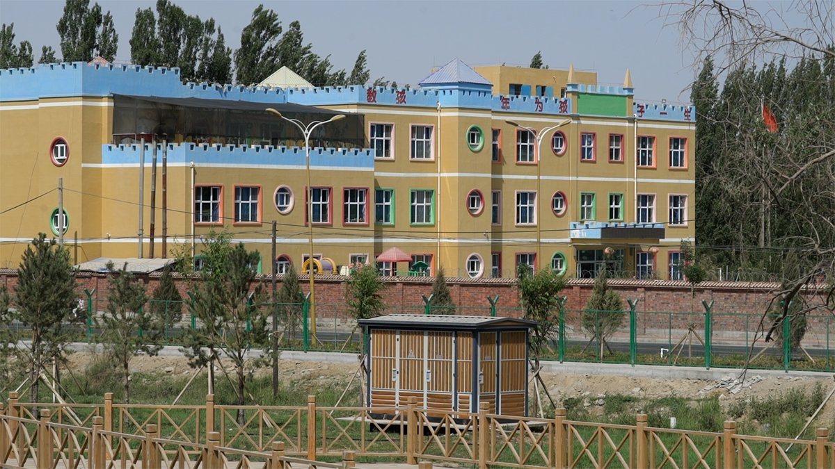 VICE新闻纪录片截屏，中国维吾尔族幼儿园，黄色，绿色和红色的窗框和蓝色的炮塔
