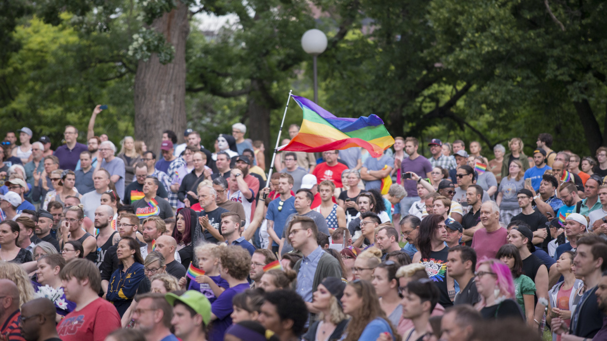 人们聚集在守夜，同性恋骄傲旗子在空气中聚集