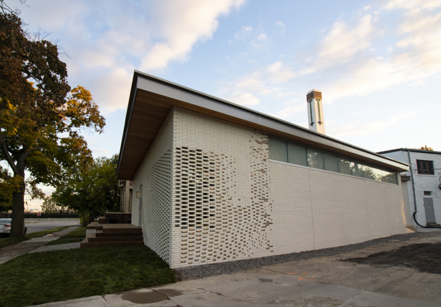 这座白色砖砌建筑的一角有缝隙和反光陶瓷装饰，是底特律设计139 (Detroit Design 139)的一部分
