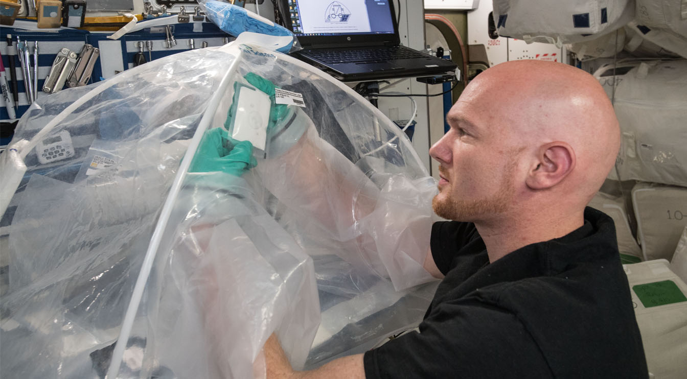 空间站上的人操纵塑料装置内的材料来制造混凝土。