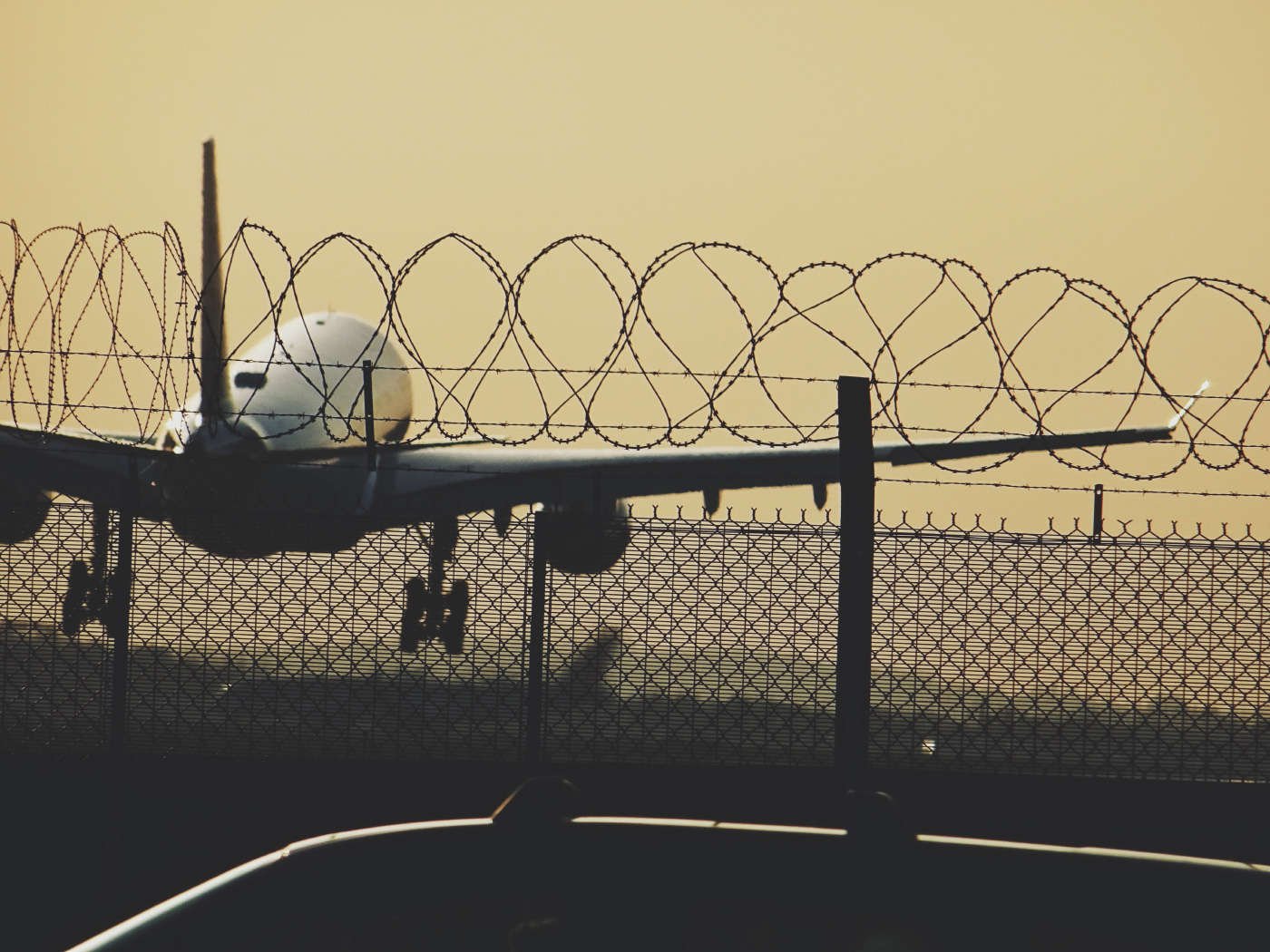 从篱芭后离开的飞机的照片在希思罗机场