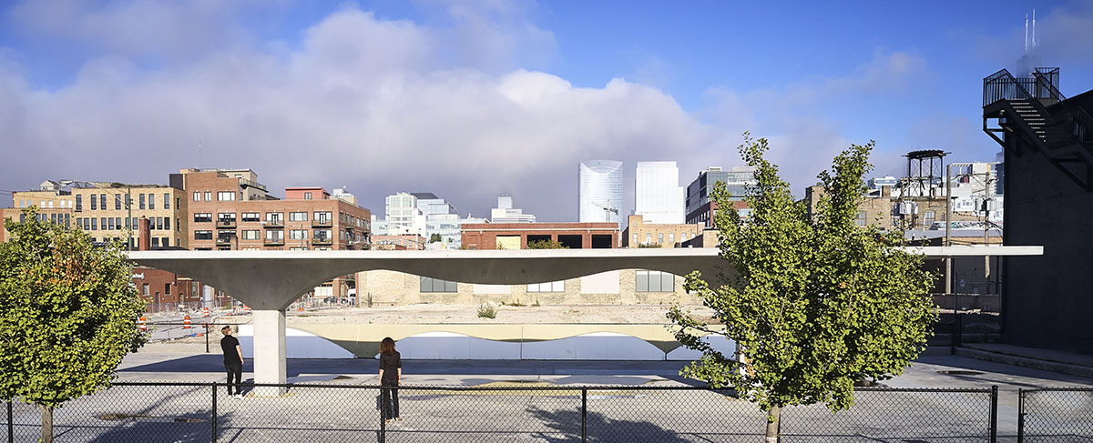 一个混凝土屋顶结构的广角镜头，以树木为背景，以城市为背景。