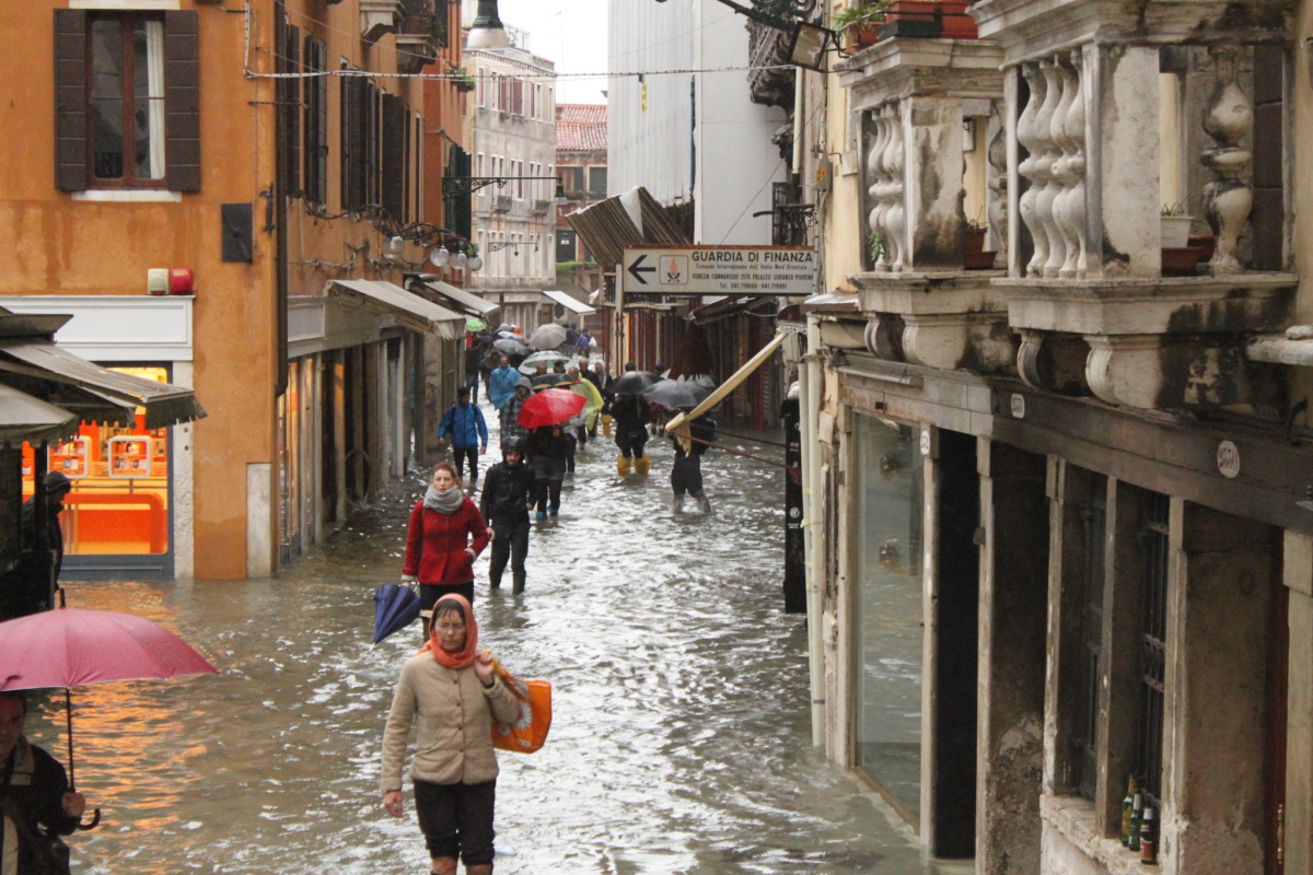 在威尼斯，人们走过被洪水淹没的街道