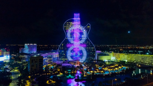 吉他形状的大厦的空中图象与紫色和蓝色光的
