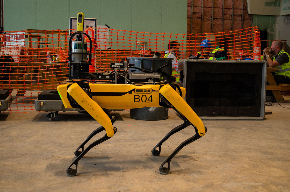 建筑工地上的一只黄色四条腿机器狗，波士顿动力公司的Spot模型之一