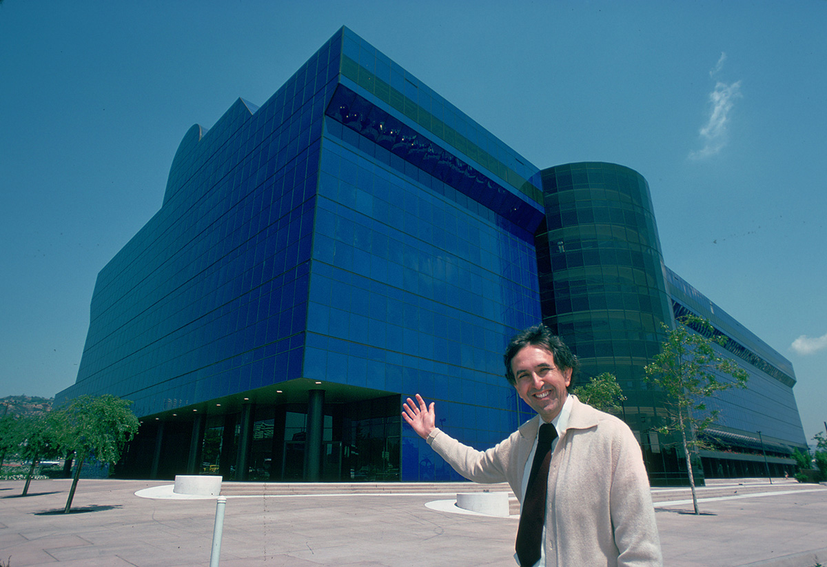 一个人站在蓝色玻璃大楼前