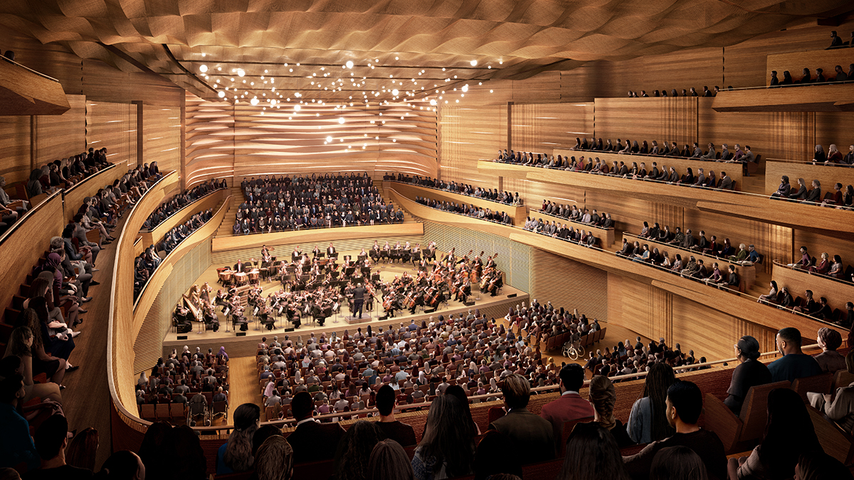 一个木制的弯曲的音乐厅，许多人坐着和纽约爱乐乐团的表演