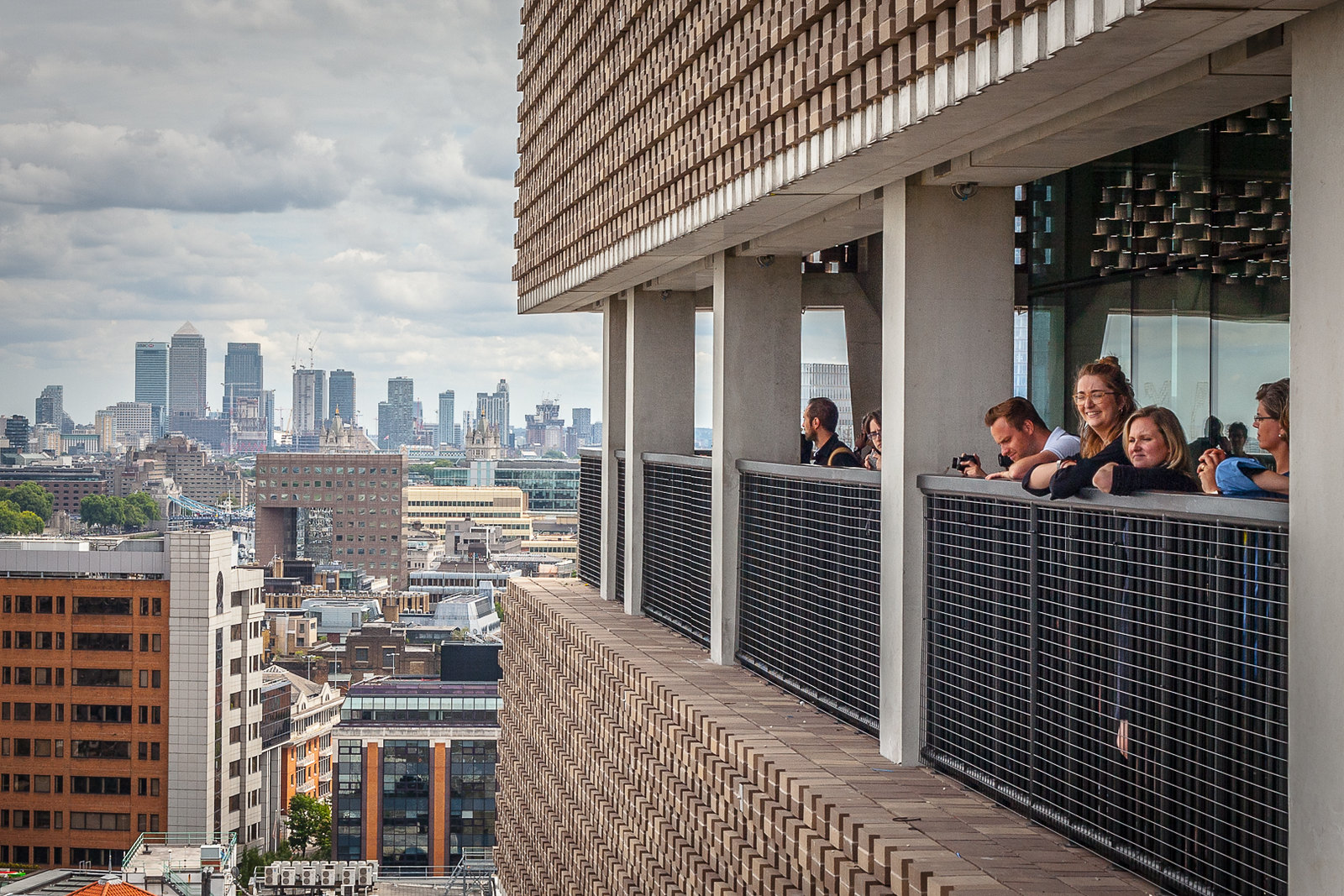 当人们悬挂在栏杆的边缘时，伦敦泰特现代的阳台景致