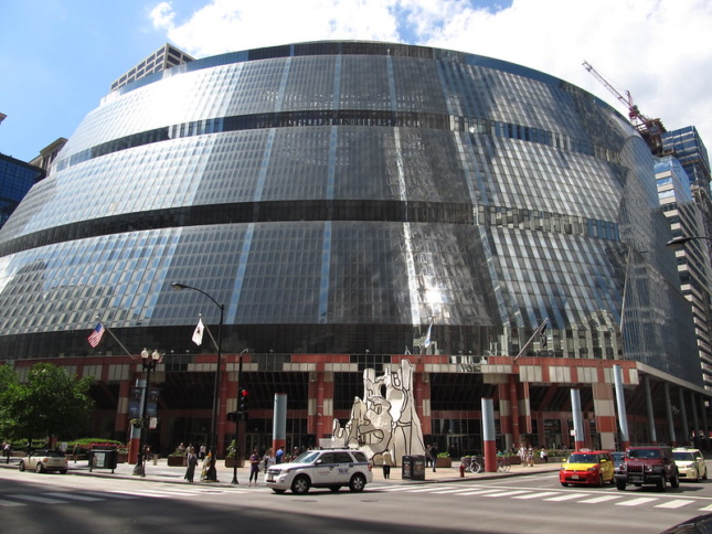 芝加哥汤普森中心的外部，展示了一个巨大的，圆形的建筑覆盖着玻璃