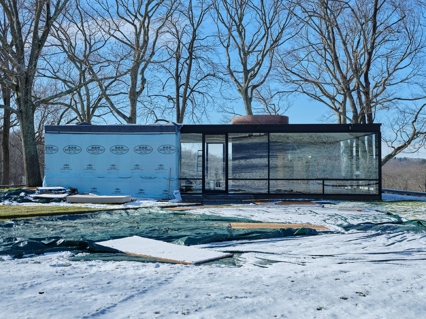 菲利普约翰逊的玻璃房子的冬天照片，挖土采斯覆盖的一半