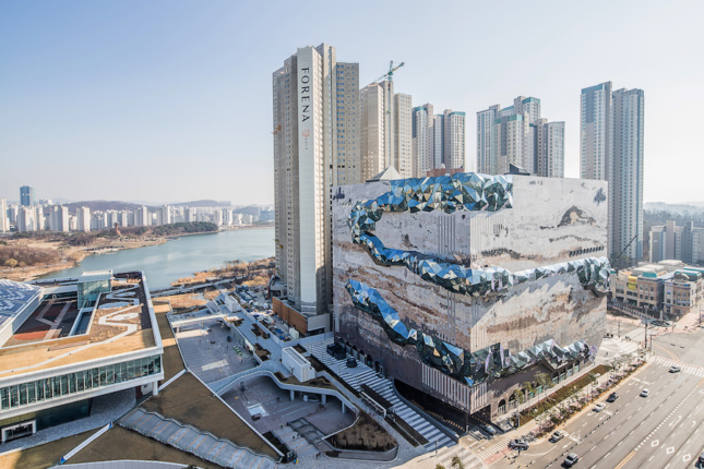 在韩国，一幢外形怪异的建筑与一群高层建筑形成鲜明对比。