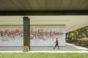 一个人走在SMUD总部一幅巨大的彩色壁画前