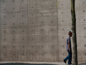 由Tadao Ando设计的混凝土墙前面的一个男人