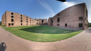 印度管理学院艾哈迈达巴德分校草坪周围砖砌建筑的全景图