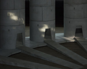 为管道安排的混凝土圆柱体照片，每个圆柱体都有通往管道的路径