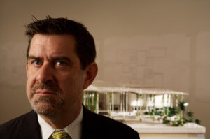 特伦斯·莱利，一个脾气暴躁的男人，正对着房子模型的照片