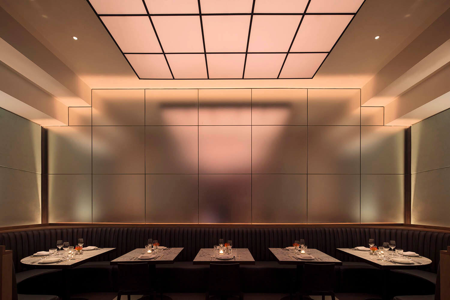 photograph of a restaurant with a prominent brushed mirror feature wall at center