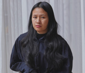 Trang Tran，一个年轻的亚裔美国妇女，在椅子上摆姿势