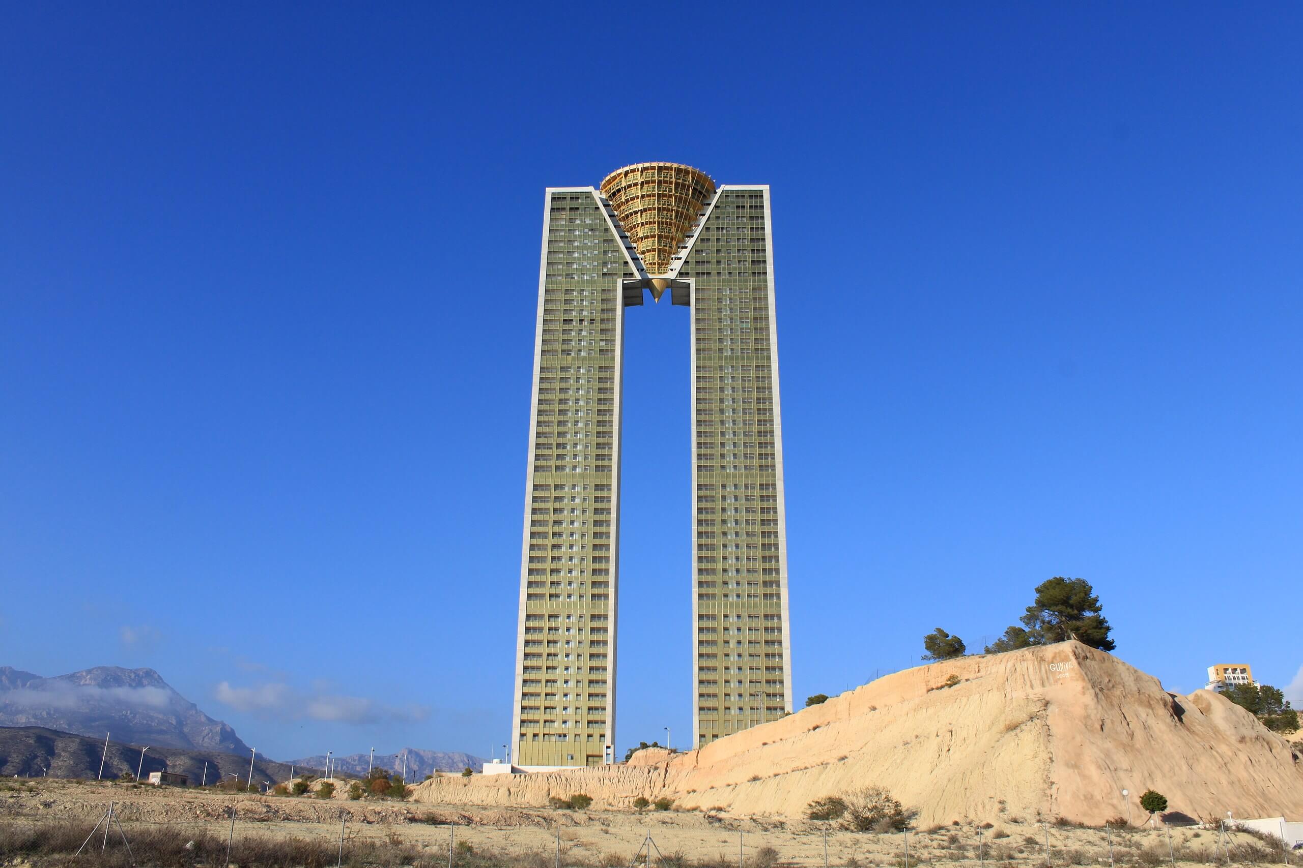 view of an m-shaped tower from an abandoned wasteland