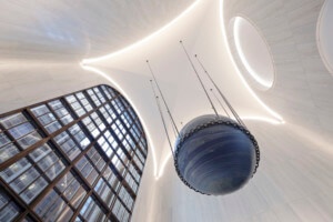 一个由alicja kwade设计的蓝色球体悬挂在麦迪逊街550号的天花板上