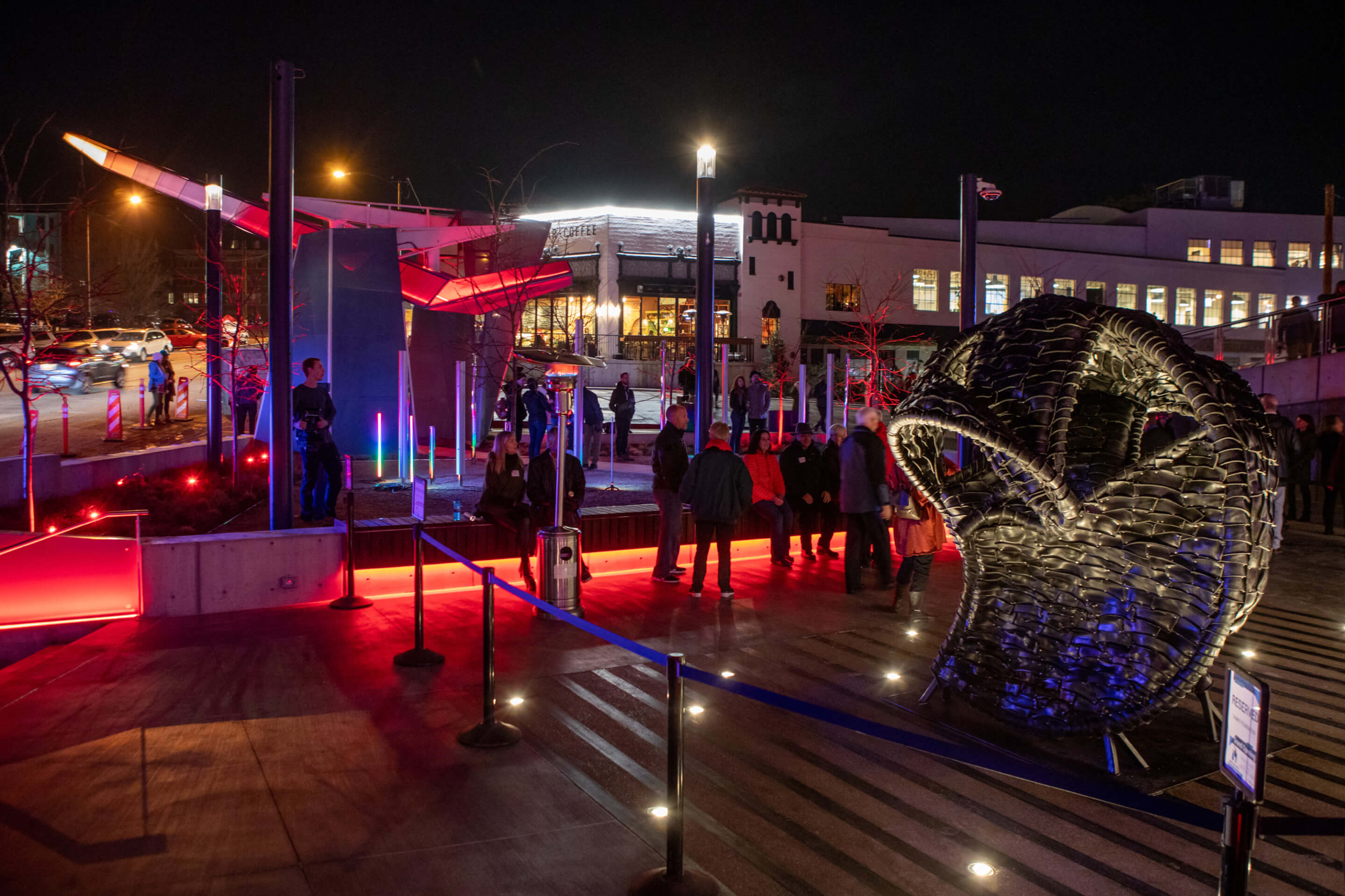 an arts plaza with sculptures and purple lighting