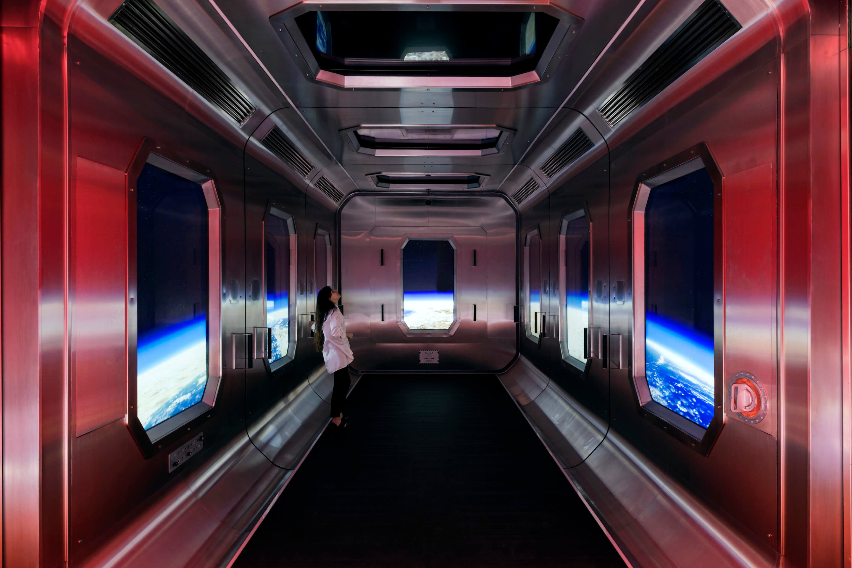 a person stands inside a large elevator fashioned as a space shuttle