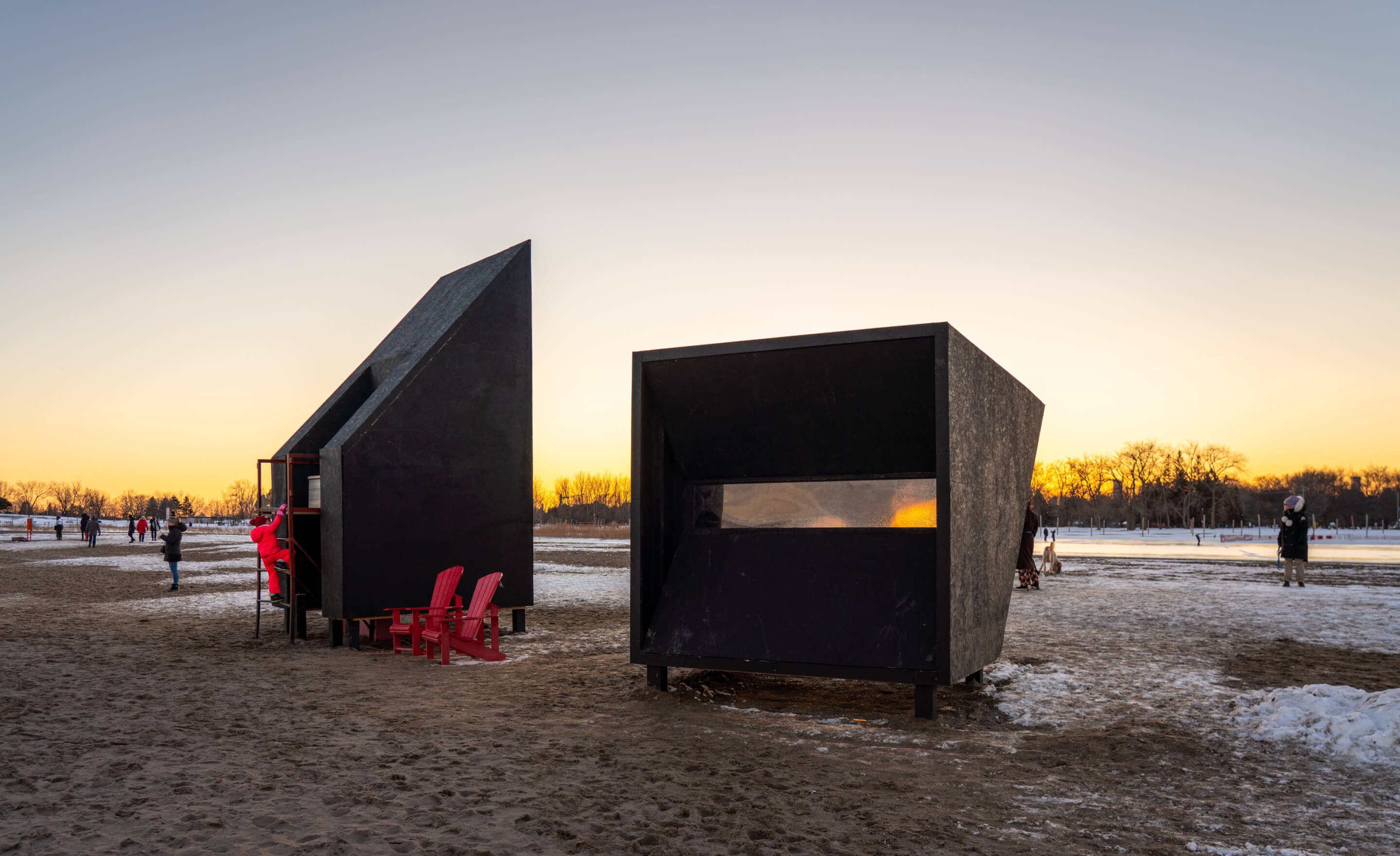 angular black beachfront pavilions flanked by red chairs