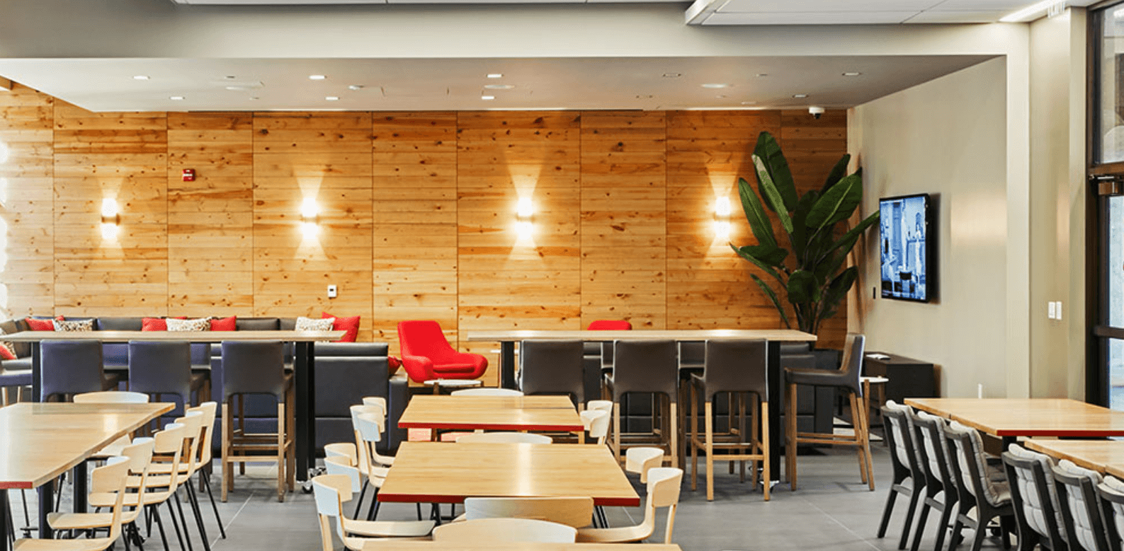 Four wall sconces illuminate an exposed wood wall in a restaurant setting
